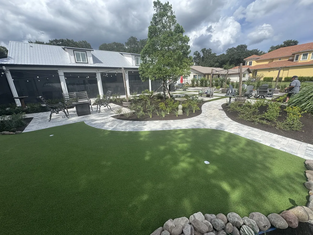 Newly planted backyard beds around a patio and putting green, from Jason Yero Group’s updated project photos